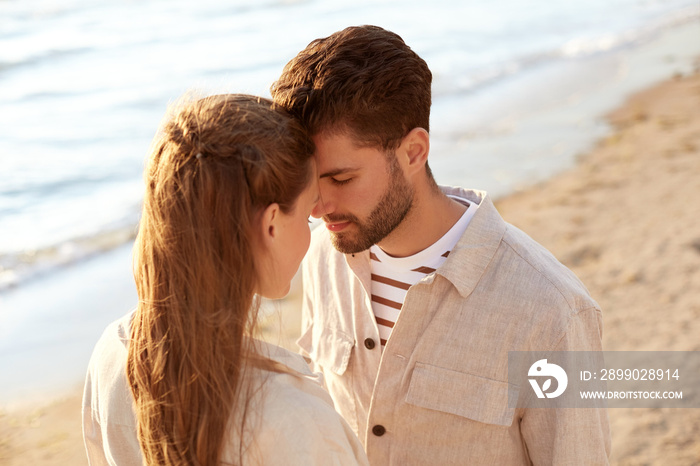 leisure, relationships and people concept - happy couple with closed eyes on summer beach