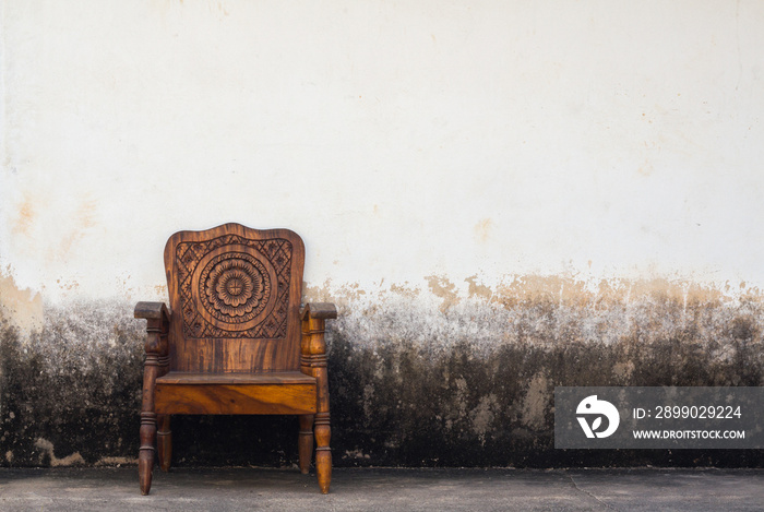 wooden chair on concrete wall