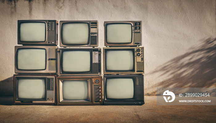 Retro of pile old television on floor in front of old wall background. , vintage TV style photo