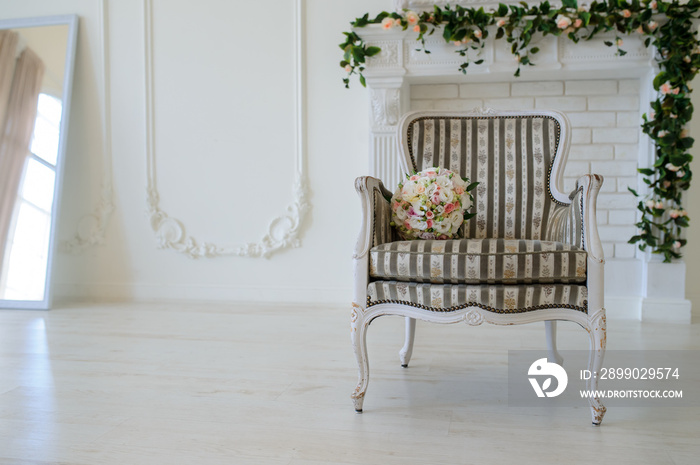 Cozy chair in the photo studio with wedding decoration and flowers bouqet