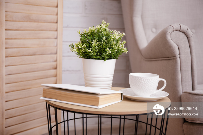 Close up of cup, plant and book on the table