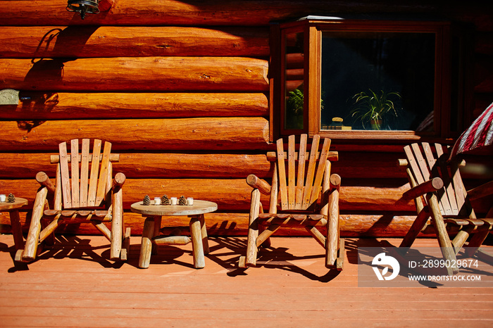 wooden rocking chairs sitting on porch next to log cabin home