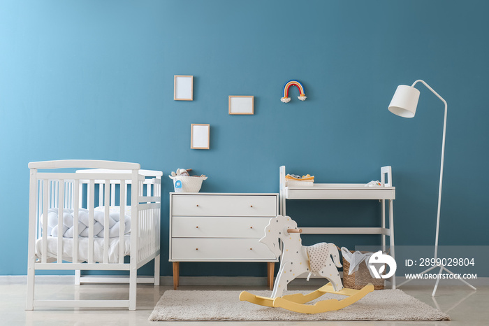 Interior of childrens bedroom with drawers, table and crib