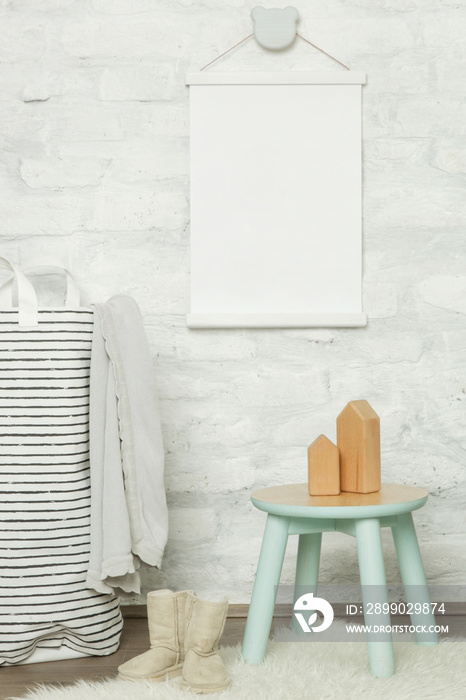 Nicely decorated kids room in pastel colors, wooden toys, furniture and blank white poster on the wa