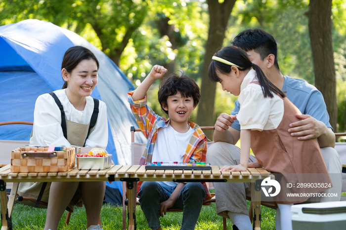 一家四口在露营地玩游戏开心欢呼庆祝