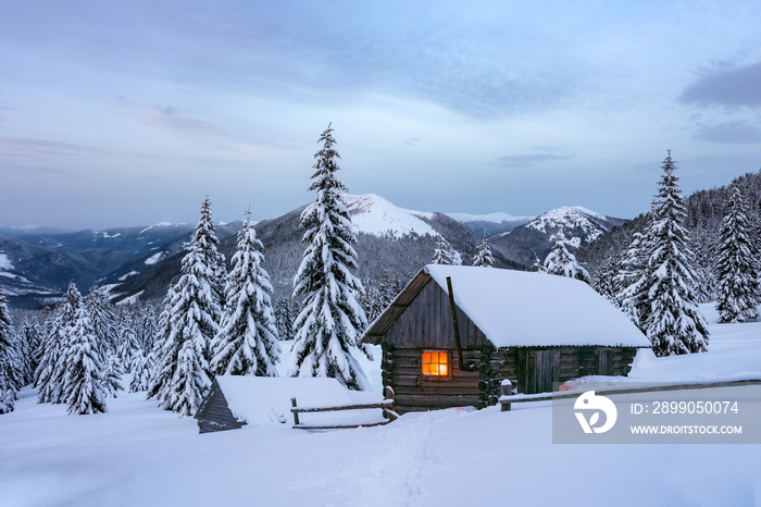 Fantastic winter landscape with wooden house in snowy mountains. Christmas holiday and winter vacations concept. Carpathians mountain, Ukraine, Europe