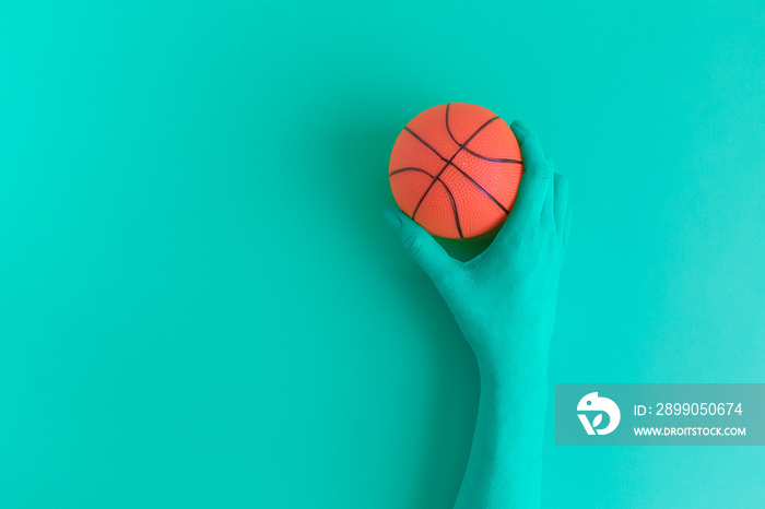 Hand holding basketball ball abstract concept.