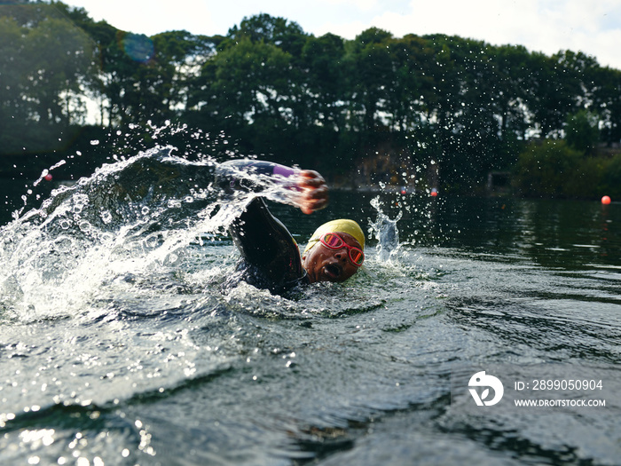 Woman in swimming cap and goggles swimming in river