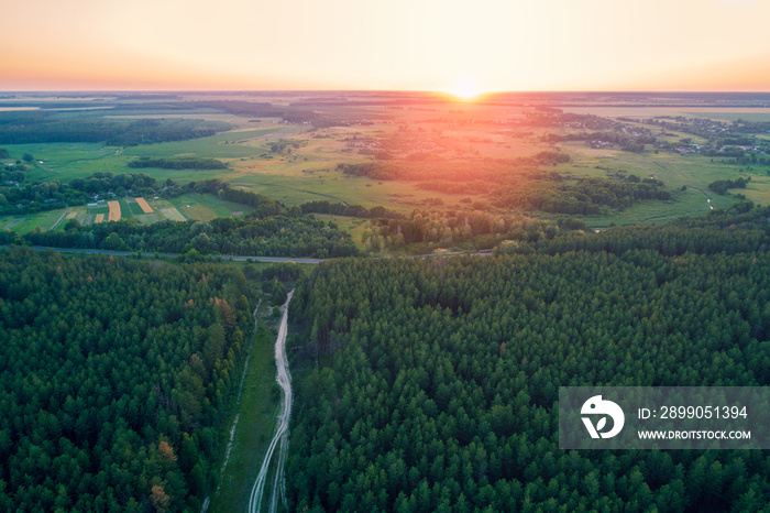 Aerial drone view of countryside, rural landscape with cloudy sky at sunset