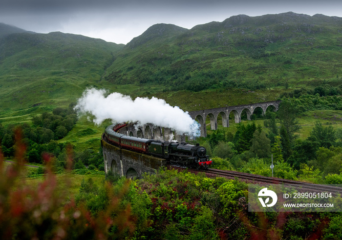 The Jacobite Steam train on Glenfinnan Viaduct in rainy summer conditions.