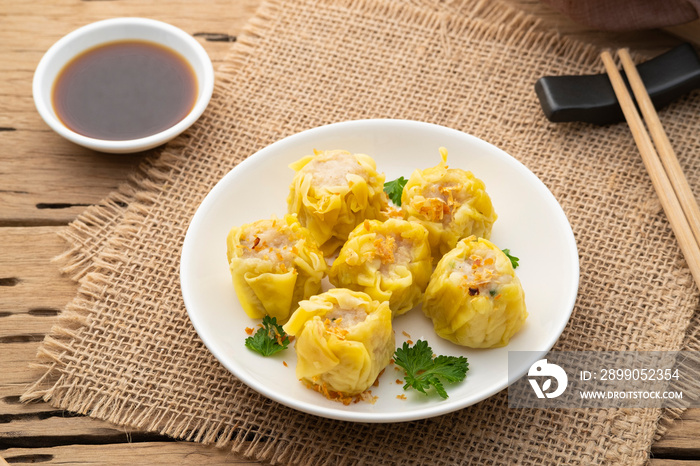 Shumai or Chinese Steamed Dumpling,meatball dumpling with wanton skin in with plate,served with soy sauce