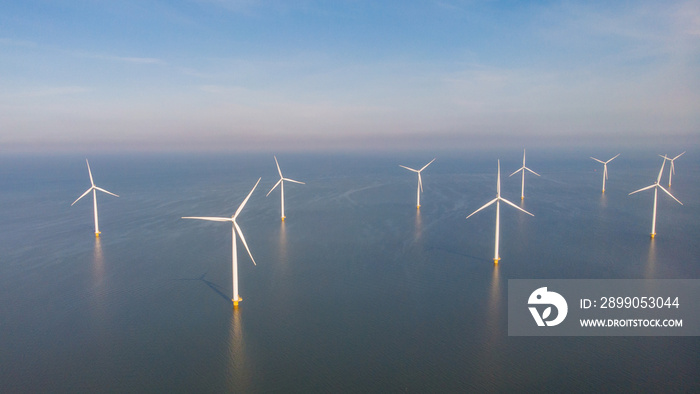 Windmill farm in the ocean Westermeerwind park, windmills isolated at sea on a beautiful bright day Netherlands Flevoland Noordoostpolder. Huge windmill turbines