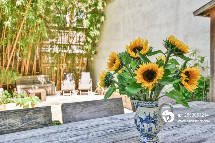 Close-up of a vase of beautiful sunflowers on the table at the backyard of the house