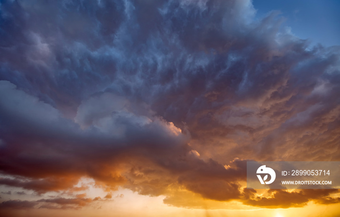 Dramatic sunset, the sun’s rays shine through the clouds.