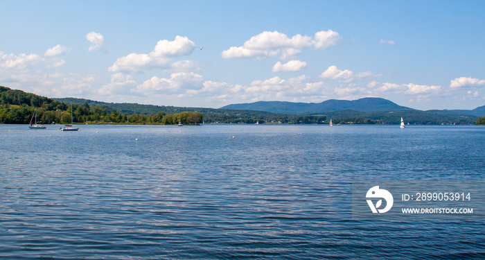 Blue sky and puffy white clouds over calm Lake Memphremagog in Vermont, USA