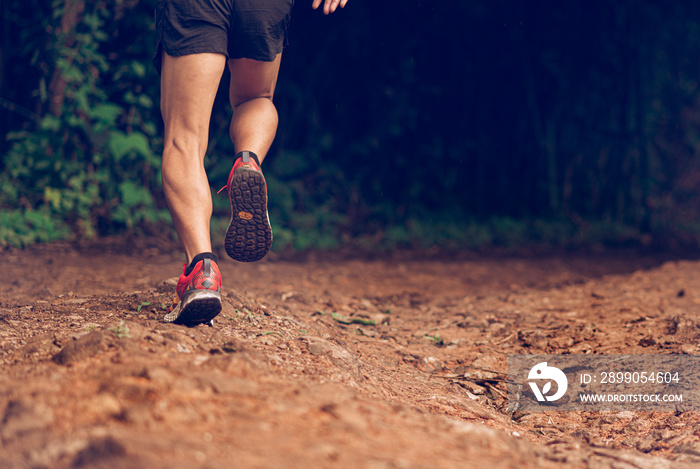 Closeup of man trail running on rocky terrain. Closeup of male feet run through rocky terrain. Focus on shoes.