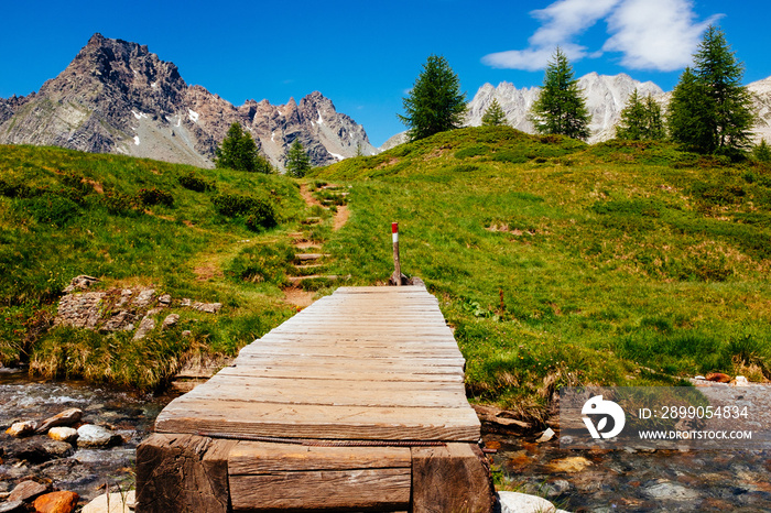 Mountain landscape with river and wooden bridge, Alpe Devero, italy