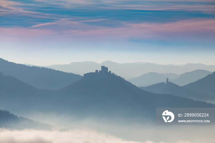 Herbstliches Panorama vom Pfälzerwald mit Berggipfeln und Tälern im Nebel. In der Bildmitte sieht man die Burg Trifels bei Annweiler