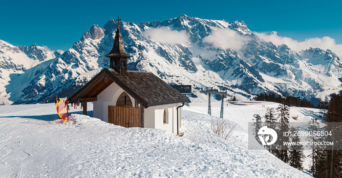 Winter landscape with a chapel and the famous Hochkoenig summit in the background at Maria Alm, Salzburg, Austria