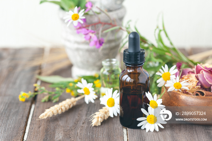 Concept of herbal, flower extracts in cosmetics. Natural organic ingredients, pure extract for beautiful healthy skin, essential oil, aromatherapy. Wooden background, close up