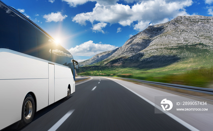 Unbranded white bus rushes along a beautiful highway.