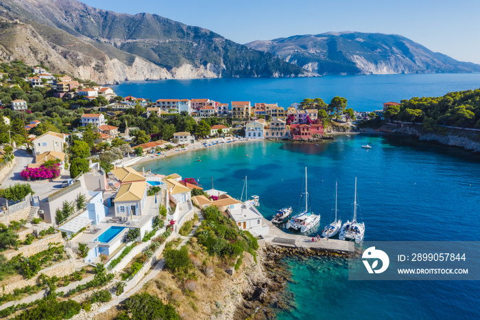 Assos picturesque fishing village from above, Kefalonia, Greece. Aerial drone view. Sailing boats moored in turquoise bay