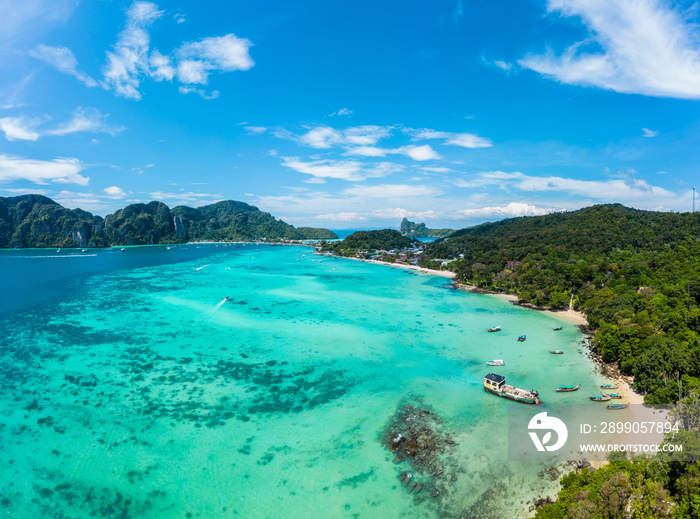 Top view of tropical island with limestone rocks and blue clear water. Aerial view of Tonsai bay with many boats and speedboats above coral reef. Phi-Phi Don Island, Thailand.