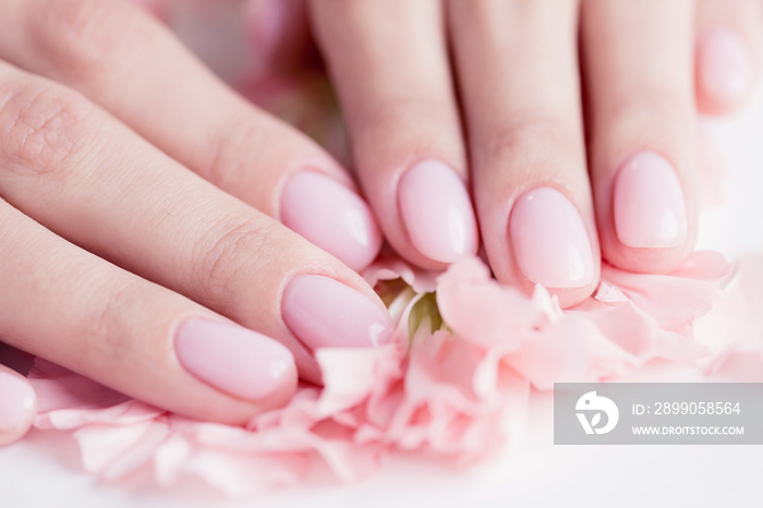 Beautiful stylish trendy woman pink manicure with flower on white background, top view. Concept beauty care spa