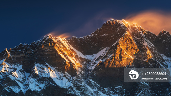 first sun lights on the peaks of Lhotse and Nutse under blue sky in Nepal