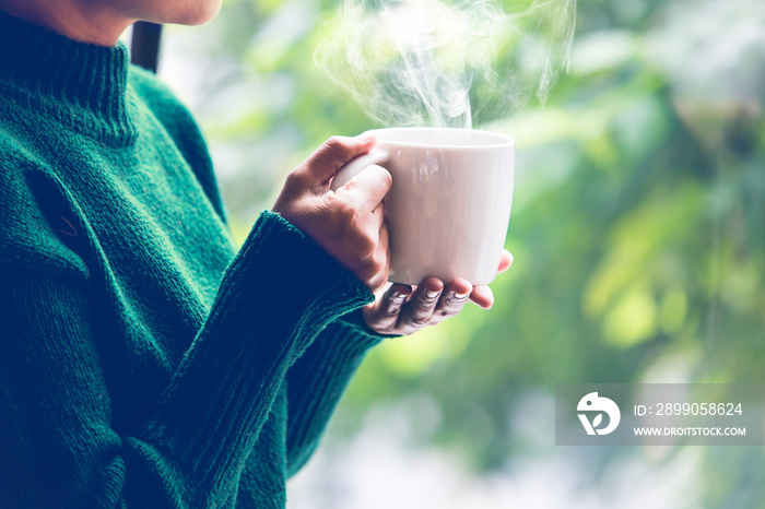 women wearing knitting sweater, drink coffee at home in the living room