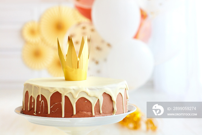 yummy birthday cake with golden crown on baby party background