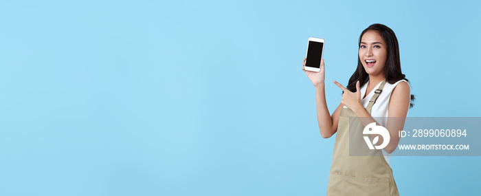 Entrepreneur asian woman showing blank screen smartphone on blue background. panoramic background.