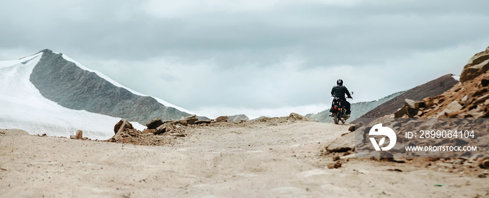 Motorbike traveler rides on mountain pass in indian Himalaya