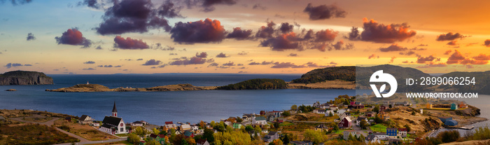 Aerial panoramic view of a small town on the Atlantic Ocean Coast. Dramatic Colorful Twilight Sky. Sunset or Sunrise. Taken in Trinity, Newfoundland and Labrador, Canada.