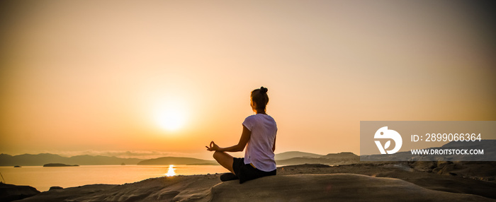 woman in white doing yoga and meditating by the sea