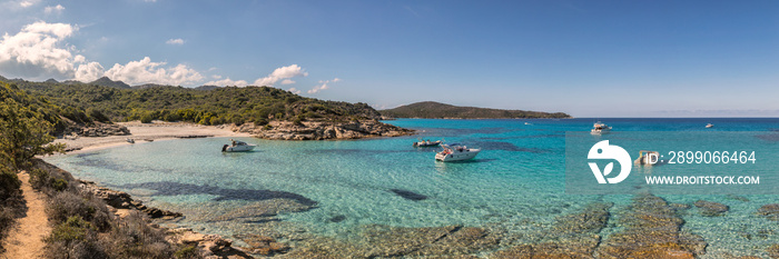 Boats in a small rocky cove with sandy beach in Corsica