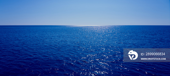 The sea goes beyond the horizon with a blue sky in the background.