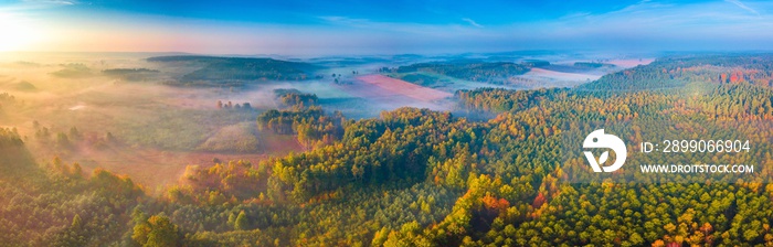 Aerial landscape with foggy sunrise over meadows and forest