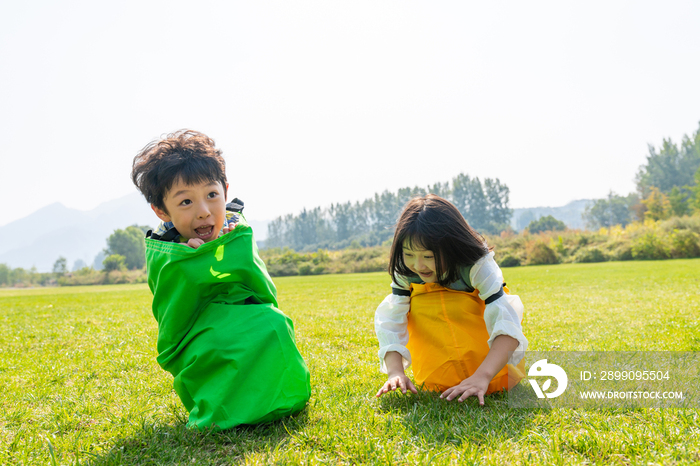 两个小孩在草地上做游戏