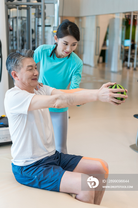 老年男子在私教的指导下健身