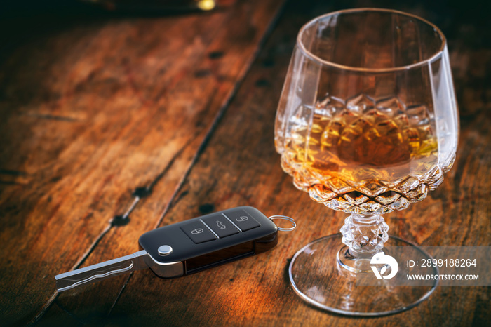 Drinking and driving concept. Car key and alcohol glass on wooden background. 3d illustration.