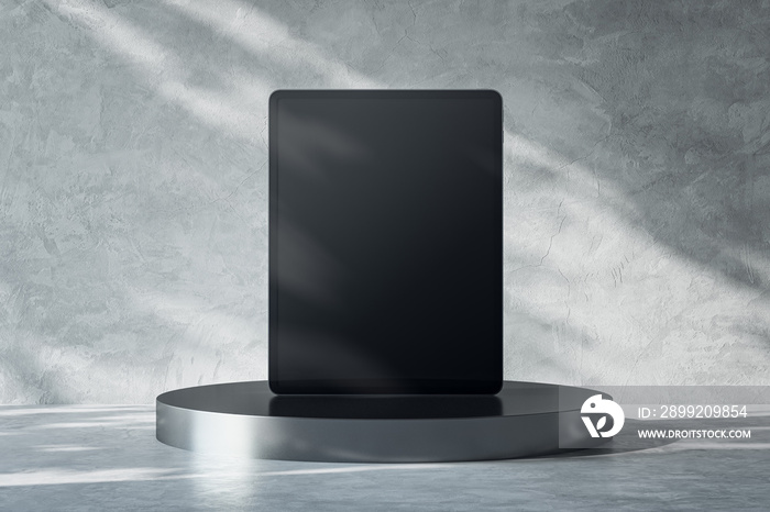 Front view on blank black digital tablet screen with place for your logo or text on dark metallic round stand on abstract sunlit light grey concrete background. 3D rendering, mockup