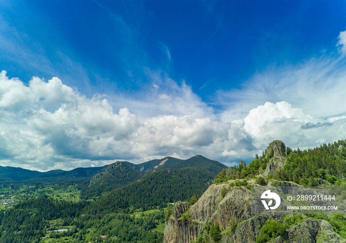 Peak of Rhodope mountain with forests against background of clouds