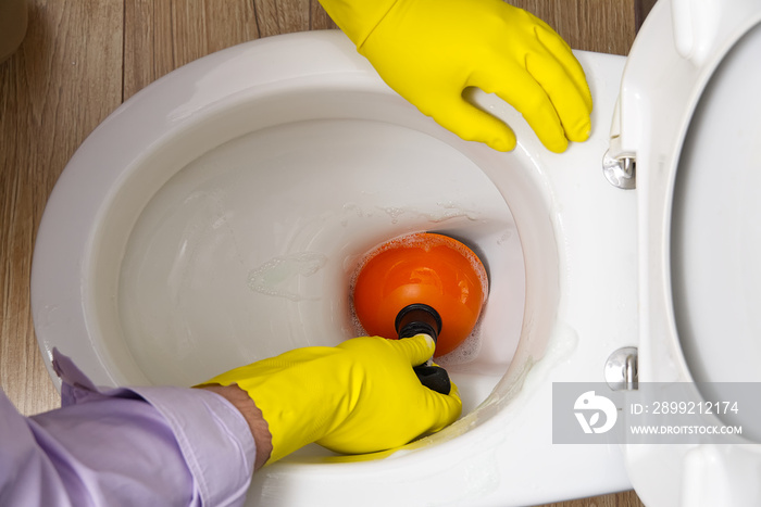 Man cleaning clogged toilet. broken overflowing toilet.