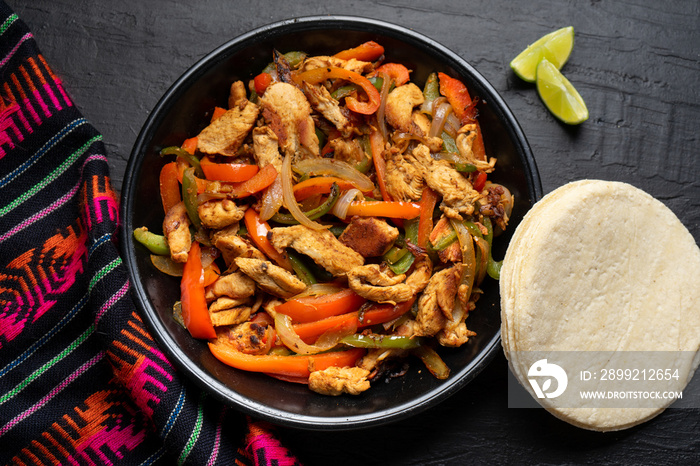 Mexican chicken fajitas on dark background