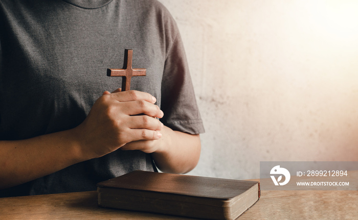 A portrait of a young woman holding a Bible tightly to her chest. ready to hold the cross Christianity is ready to show love for God.