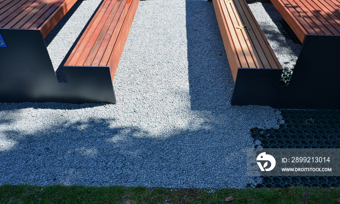 installation of a plastic mat as a substitute for lawn. plastic permeable tiles are filled with a fine putty. under the benches is a reinforced grass paving