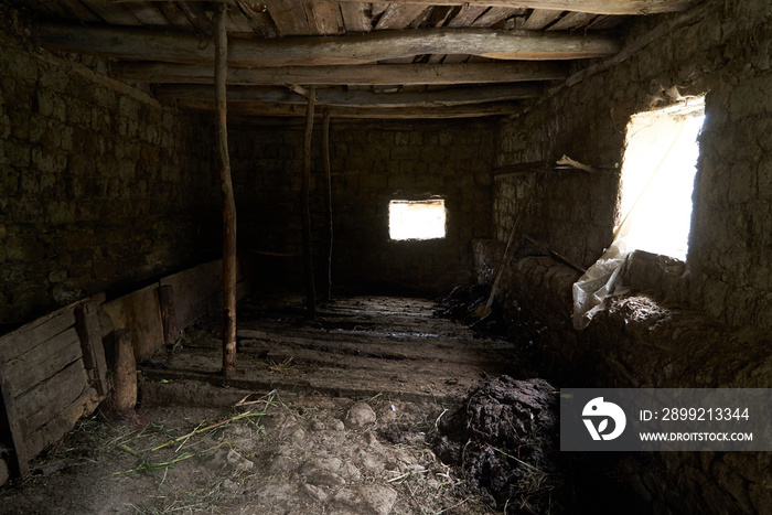 Old rustic clay cowshed interior with window and manure for fertilizer inside