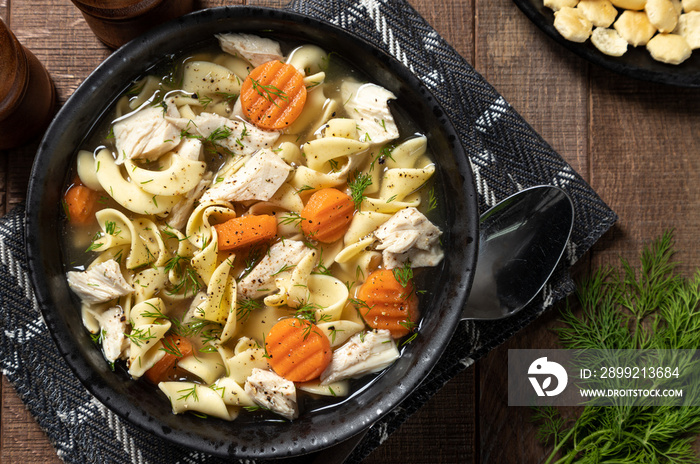 Bowl of chicken noodle soup on a wooden table