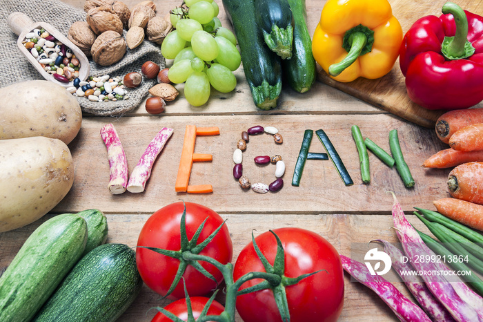 vegan word on wood background and vegetable - food